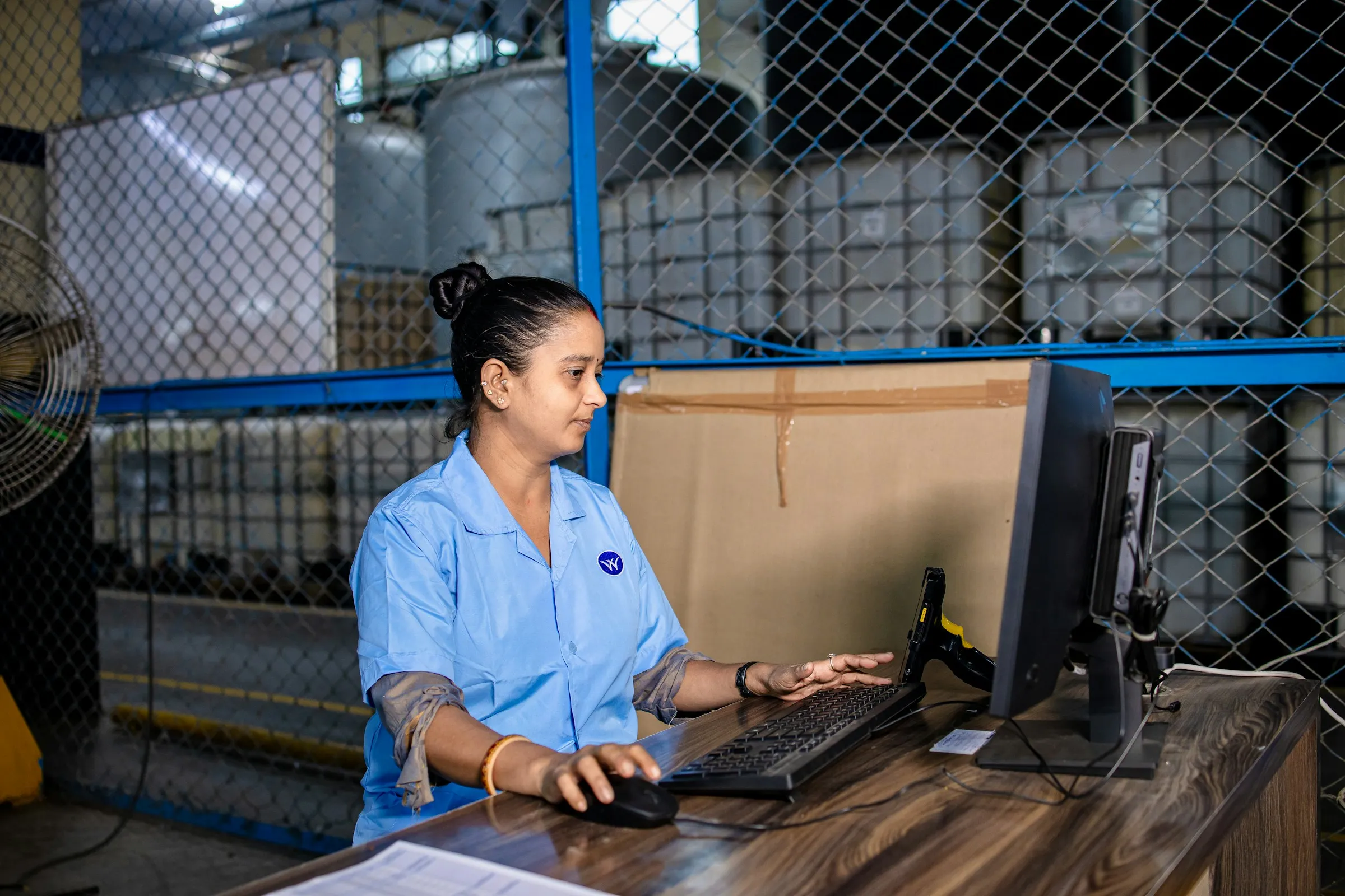 Empleada de oficina trabajando con el ordenador en un almacén